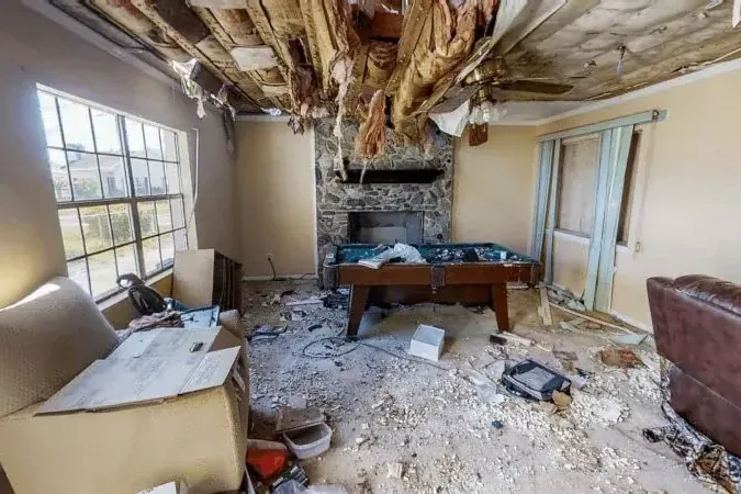 Ceiling and insulation collapsed into a living room after monsoon rain got through the roof