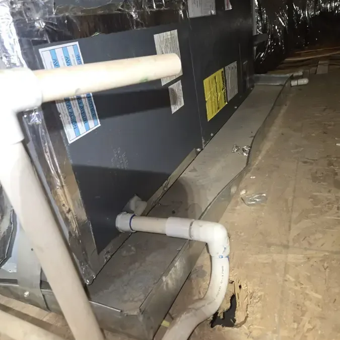 An attic air handler with its PVC condensate drain line